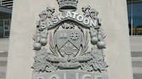 Woman charged after elderly Saskatoon woman hit with gardening tool and cop punched in the face