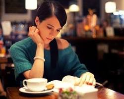 Image of person reading a book in a coffee shop