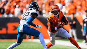 Ja'Marr Chase runs with the ball against Travis Hunter during a Bengals Jaguars game