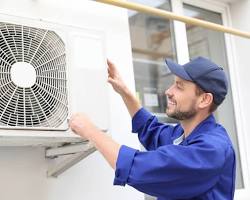 Image of person installing an air conditioner