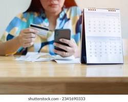 person holding a credit card looking at a calendarの画像