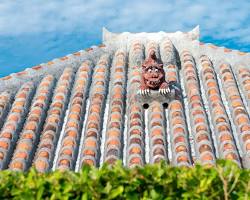 traditional Okinawan village on Taketomi Island, with red tile roofs and stone walls lining the streets.の画像