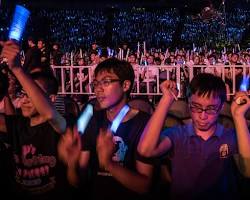 Image of fans at concert holding lightsticks glowing cheering fandom identity concept photo reference