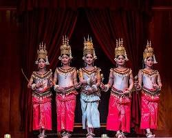 Traditional Cambodian Apsara dancers in ornate costumes performing on stage.