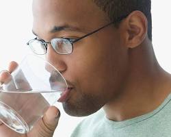 person drinking water from a glass