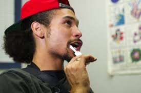 Luis Hough swabs his mouth with an HIV test while at the Department of Motor Vehicles in Washington, DC on July 12, 2012. The testing program started in ... - hiv-testing-us-routine-practice