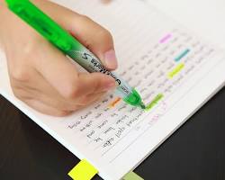 person studying with a highlighter and sticky notesの画像