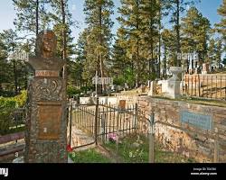 Image of graves of Wild Bill Hickok and Calamity Jane in Mount Moriah Cemetery, Deadwood, South Dakota, adorned with flowers and mementos left by visitors