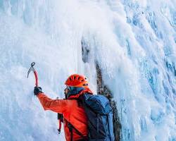 person climbing a mountain with a backpack full of tools