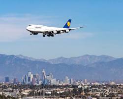 Image of Lufthansa plane flying over Los Angeles skyline
