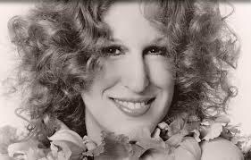 ... of Bette Midler talking on the phone to a young cancer patient named Anna Greenberg as she sits in her hospital bed with loved ones gathered round her. - bette-midler-8-25-11