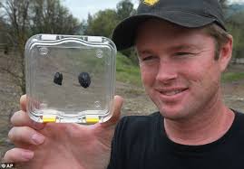 Tiny treasures: Robert Ward shows off the two small lumps of meteorite rock he discovered in Lotus, California. The rocks are worth a combined total in ... - article-0-12C5D1E5000005DC-576_634x441