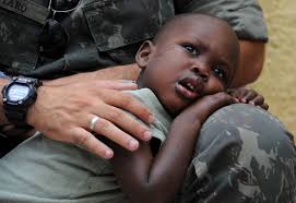 A Brazilian soldier of the MINUSTAH force hugs an Haitian child orphaned by the 2010 earthquake (Photo Credit: Vanderlei Almeida/AFP/Getty Images). - 3