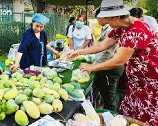 Imagen de farmers participating in a local market, selling fresh, diverse produce directly to consumers