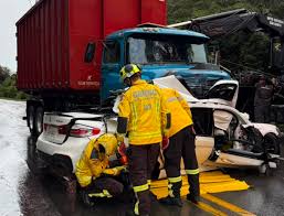 Mulher de 26 anos morre após carro de luxo rodar na pista e parar embaixo de caminhão na SC-418