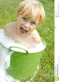 A cute happy young child is sitting in a bucket full of soap bubbles and water outside on a sunny summer day. MR: YES; PR: NO - child-bubbly-wash-basin-cute-happy-young-sitting-bucket-full-soap-bubbles-water-outside-sunny-summer-day-32795108