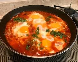 Imagem de Shakshuka, prato de ovos cozidos em molho de tomate