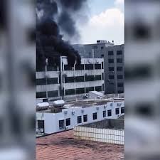 People seen on rooftop as fire rips through shoe factory in China