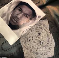 The iconic image of Trayvon Martin used to create the tattoo plus the outline of it used by Roman Abrego at Artistic Element in Los Angeles - article-0-1B627830000005DC-932_634x621