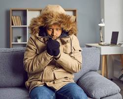 Image of person shivering in a winter coat indoors