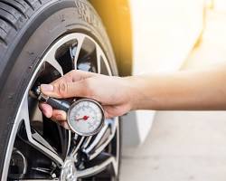 Image of tire pressure gauge being used to check tire pressure