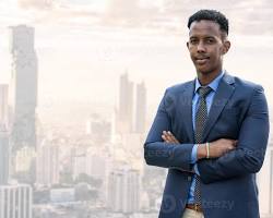 Image of young person confidently looking out over a city skyline
