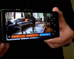 smartphone displaying a home security app with realtime camera footage and alarm activation options.の画像