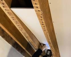 Зображення: wooden beam in a gypsum board wall cavity