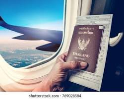 Image of someone holding a passport with a plane in the background