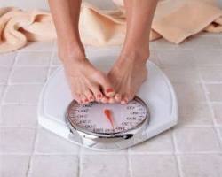 person weighing themselves on a scale