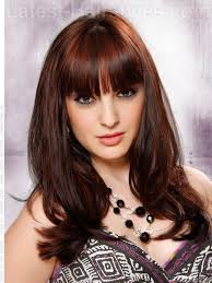 The model has extremely thick hair that is kept looking full with blunt bangs and longer, point-cut layering. Brunette Style with Lots of Volume and Long ... - brunette-style-for-long-hair-with-bangs-and-lots-of-volume