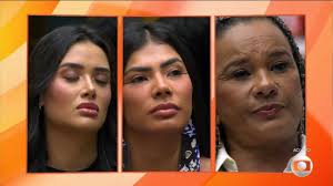 Três mulheres em um telão, com expressão séria. Possivelmente participantes de um reality show.