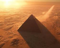 Image of Great Pyramids of Giza at sunset, casting long shadows across the desert landscape.