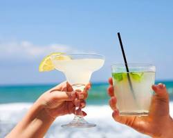 Image of someone sipping a margarita on a California beach
