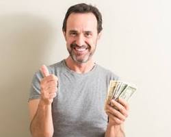 Image of someone holding up a dollar bill with a big smile