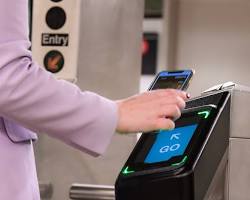 Image of person using a phone to tap and go on the NYC subway