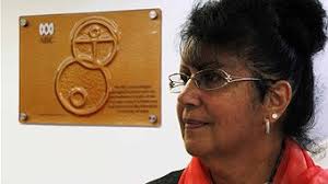 Artist Judith-Rose Thomas and the plaque that she designed for the ABC studios in Launceston (Tim Walker - ABC Local) - r1122517_13756383