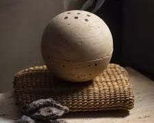 Hình ảnh về natural stone incense burner with smoke in a garden