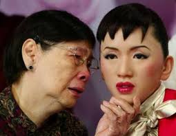 Tam Mei-kam (L), mother of the late Hong Kong singer Anita Mui, looks at a wax figure of Mui as she unveils it at Madame Tussauds in Hong Kong March 22, ... - xin_560302230946671278728