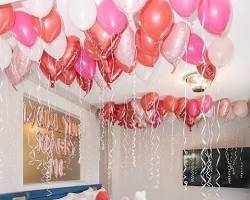 صورة room decorated with balloons, lights, and flowers