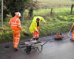 Image of happy construction worker fixing a pothole