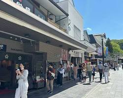 couple strolling along the charming street lined with shops and cafes in Dazaifu Tenmangu.の画像