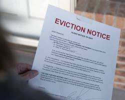 Image of stressedout tenant looking at eviction notice