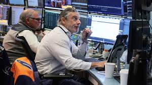 Traders monitor the Dow Jones Industrial Average at the New York Stock Exchange