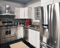 Image of kitchen with gray cabinets, white countertops, and stainless steel appliances