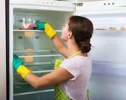 Hình ảnh về person cleaning the inside of a refrigerator