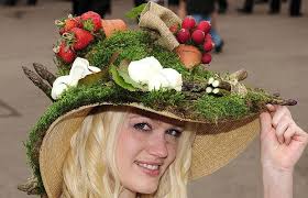 Racegoer Beth Ridley wears a hat decorated with garden produce including radish, asparagus, strawberries, potatoes and roses at York Racecourse. Picture: PA - strawberry-hat_1403741i