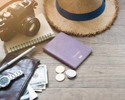 Image of traveler's essentials: passport, wallet, phone, camera