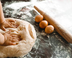 Imagine cu Children kneading dough with their hands.