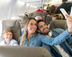 happy family holding hands in front of an airplaneの画像
